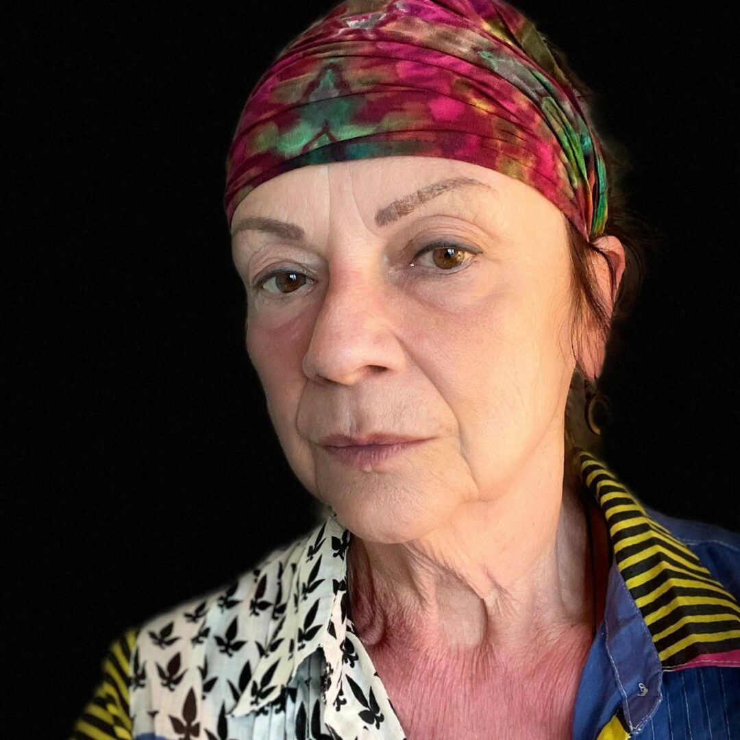 A woman with a colorful head scarf on.
