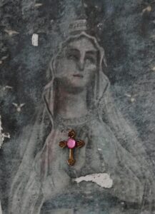 A cross is placed on the back of an old photo.